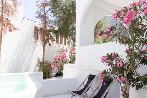 a room with pink flowers and a window at Cavo Bianco Boutique Hotel & Spa in Kamari