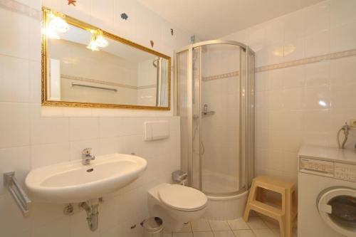 a bathroom with a sink and a toilet and a shower at Appartement-Mecking in Munkmarsch