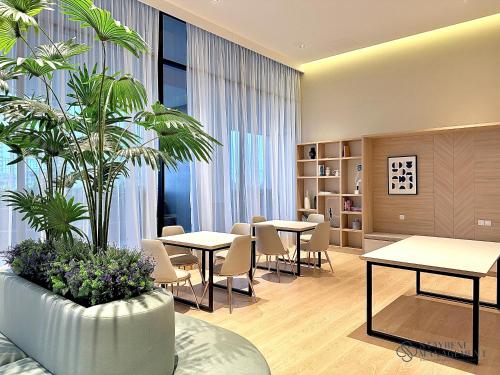 a waiting area with tables and plants in a room at Twin Tower Residence Johor Bahru by Stayrene in Johor Bahru