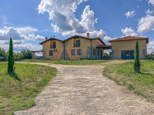 a large house on a field with a dirt road at Villa Tuscia apartments in Tuscania