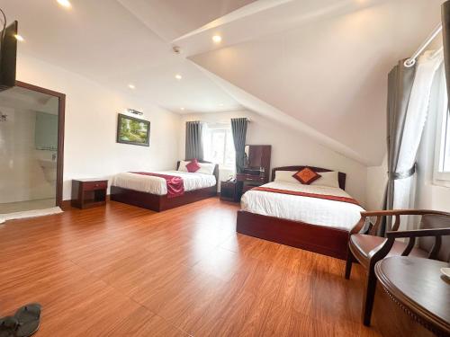 a hotel room with two beds and a table at White Horse Dalat Hotel in Da Lat
