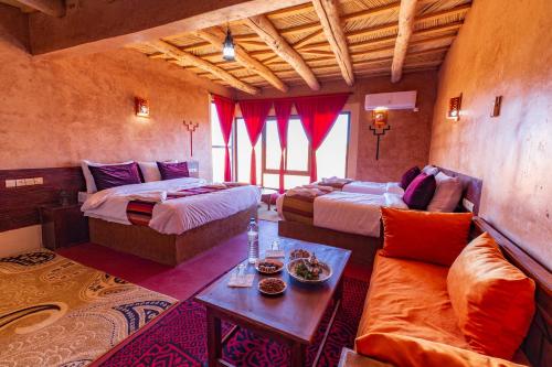 una camera d'albergo con due letti e un divano di Palais Ksar Lamane a Aït Ben Haddou