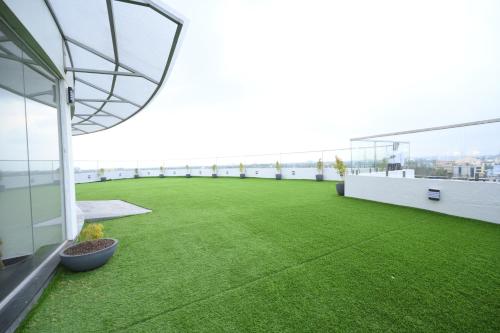 a balcony with green grass on the roof of a building at Fort Manor in Trivandrum