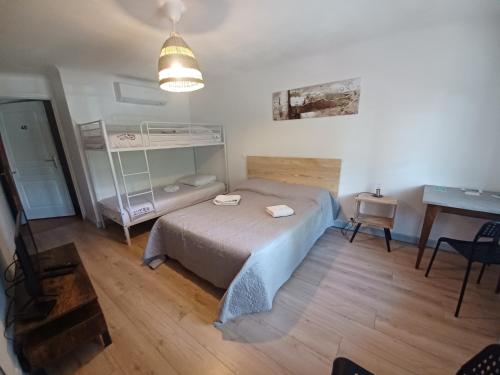 niewielka sypialnia z łóżkiem i biurkiem w obiekcie Le Grand Hotel w mieście Aups