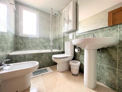 ein Badezimmer mit einem weißen Waschbecken und einer Toilette in der Unterkunft Gemelos 22-3-12 in Benidorm