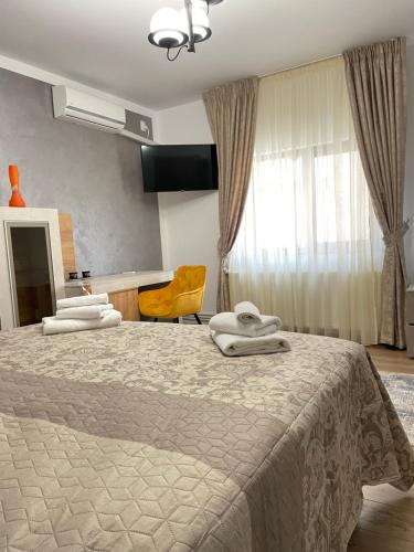 a bedroom with a bed with two towels on it at Burebista Residence in Deva