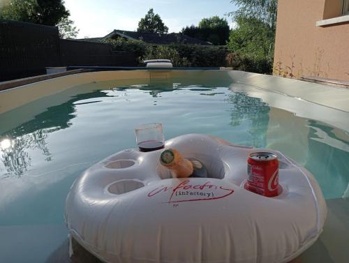 balsa alatable en una piscina con una bebida y una lata en maison 70m2 calme vue sur forêt, en Salles