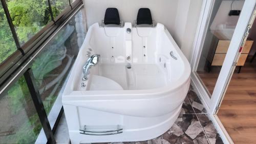 a white bath tub in a room with a window at Burahan Suit Hotel in Çamlıhemşin