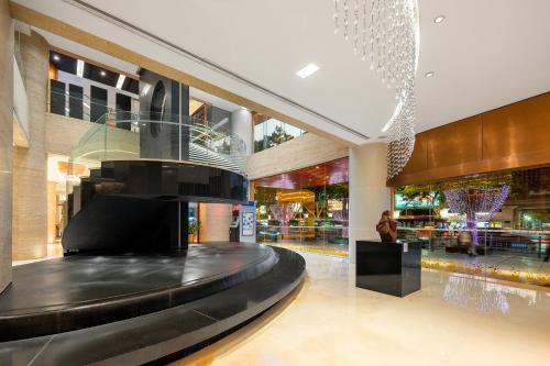 a lobby of a shopping mall with a black bench at Jianguo Hotel Guangzhou in Guangzhou