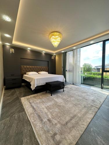 a bedroom with a large bed and a large window at SAPANCA ALHARRAN VILLA in Sapanca