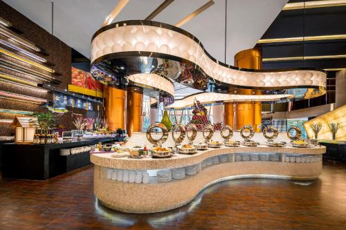 a restaurant with a counter with food on it at Jianguo Hotel Guangzhou in Guangzhou