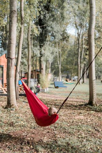 a child sleeping in a red hammock in a park at Riverside Cabins in Shrewsbury