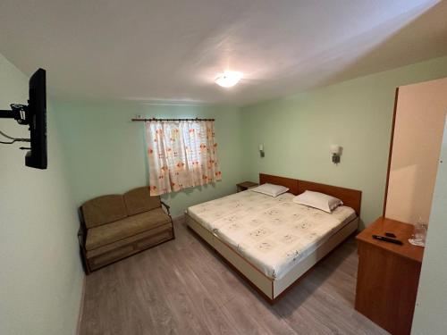 a small bedroom with a bed and a chair at Zora Camping - Bungalows in Obzor