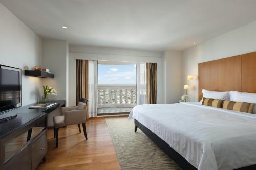 a hotel room with a bed and a desk and a window at lebua at State Tower in Bangkok