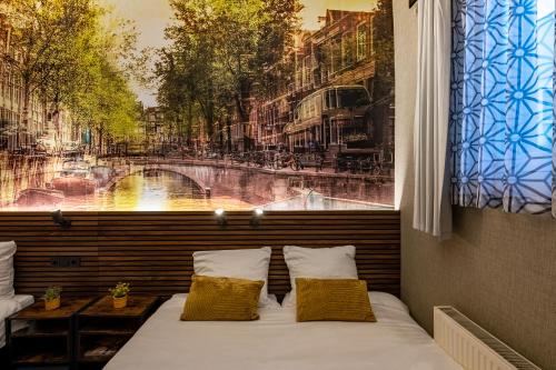 a bed in front of a window with a painting at Historic Centre Hotel in Amsterdam