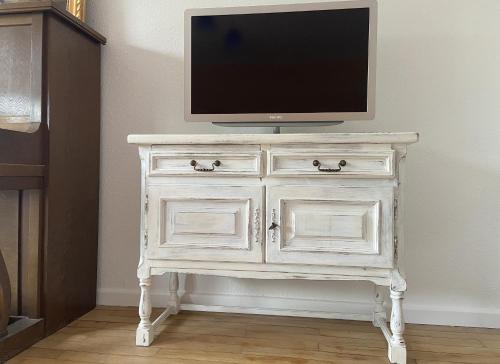 a white dresser with a television on top of it at Villa Bulla-ÿ in Bullay