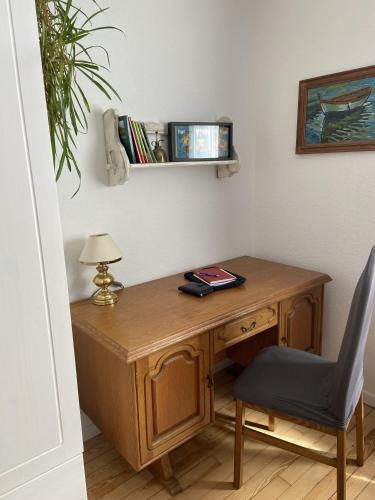 a wooden desk with a chair and a lamp at Villa Bulla-ÿ in Bullay