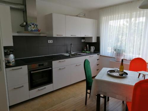 a kitchen with white cabinets and a table with a dining room at Villa Bulla-ÿ in Bullay