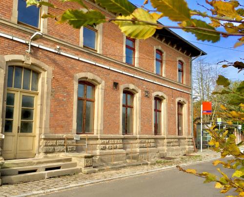a brick building on a street in front at Bahnhof Nebra in Nebra