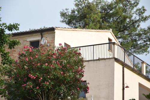 a house with a balcony and a tree at Casale di Maro in Monte Giberto