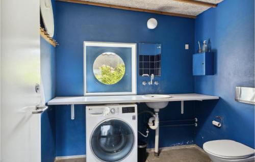 een blauwe badkamer met een wasmachine en een wastafel bij Cozy Home In Vejby With Kitchen in Vejby