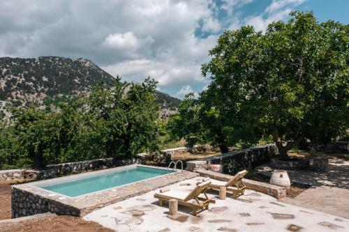 una piscina con 2 tumbonas junto a ella en Nomas Home Imbros, en Chóra Sfakíon