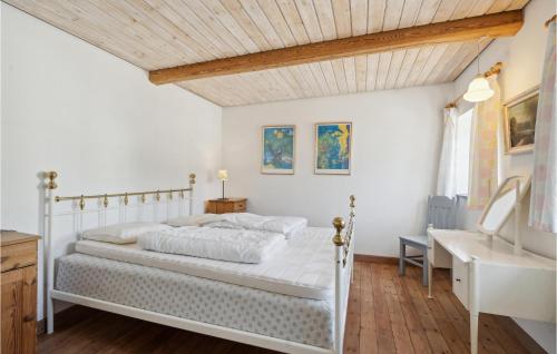 een slaapkamer met een wit bed en een wastafel bij 2 Bedroom Pet Friendly Apartment In Tranekr in Skattebølle