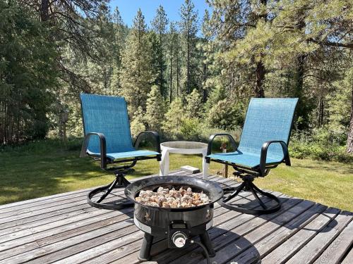 two chairs and a fire pit on a deck at Pine Tree Cottage by NW Comfy Cabins in Leavenworth
