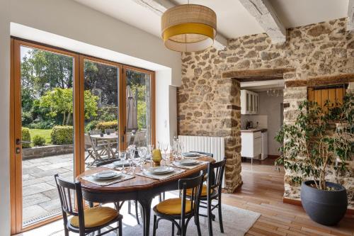une salle à manger avec une table et des chaises en bois dans l'établissement L'Ecrin du Val - Charmante maison pour 6 et jardin, à Saint-Malo