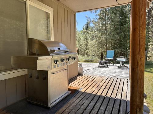an outdoor kitchen with a stove and a patio at Pine Tree Cottage by NW Comfy Cabins in Leavenworth