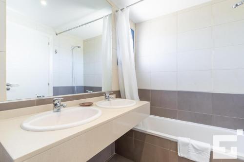 y baño con 2 lavabos, bañera y espejo. en Apartamento Estrella de Calpe 8C - Grupo Turis, en Calpe