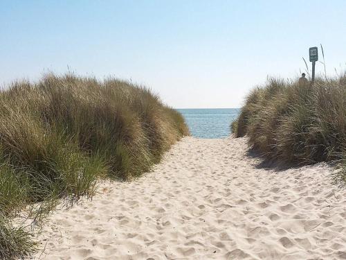 un chemin à travers le sable sur une plage dans l'établissement 6 person holiday home in S by, à Sæby