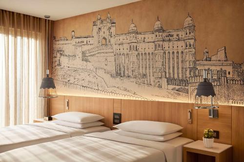 two beds in a room with a drawing on the wall at Hyatt Place Jaipur Malviya Nagar in Jaipur
