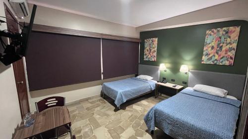 Habitación de hotel con 2 camas y mesa en Hotel Varadero Internacional en Guayaquil