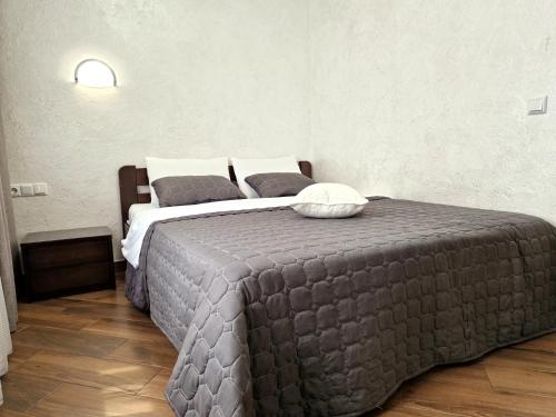 a bedroom with a bed with a gray blanket at Apartment on Belvedere in Ivano-Frankivsʼk