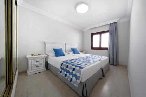a white bedroom with a bed and a window at Labranda Los Cocoteros in Puerto del Carmen