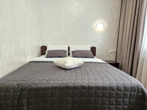 een slaapkamer met een bed met een kussen erop bij Cozy apartment on Belvedere in Ivano-Frankivsʼk