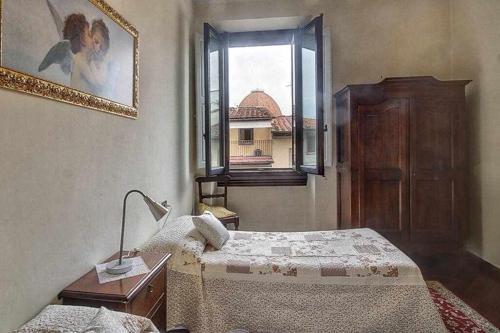 Schlafzimmer mit einem Bett und einem Fenster in der Unterkunft Spettacolare Vista Duomo Con Terrazza in Florenz