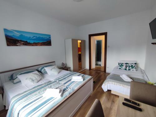 a bedroom with two beds and a tv on the wall at Apartment Palma in Zadar