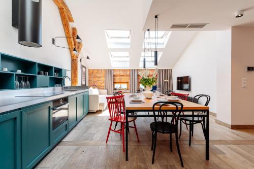 een keuken met blauwe kasten en een tafel met stoelen bij Penthouse Stradom by LoftAffair in Krakau
