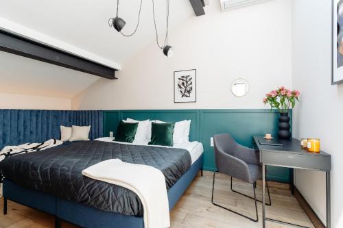 um quarto com uma cama azul e uma secretária em Penthouse Stradom by LoftAffair em Cracóvia
