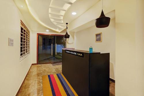 a lobby with a black counter and a colorful rug at Capital O De Alphabet Kakinada in Kākināda