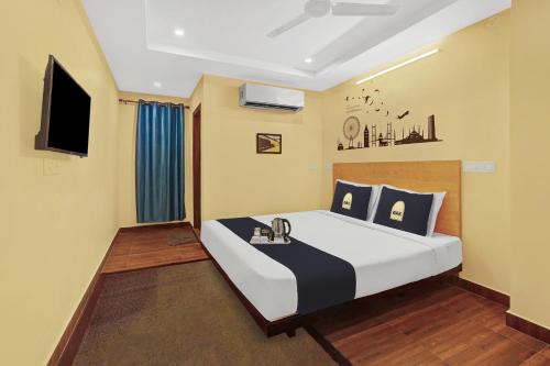 卡基納達的住宿－Super Capital O De Alphabet Kakinada，一间卧室配有一张大床和一台平面电视