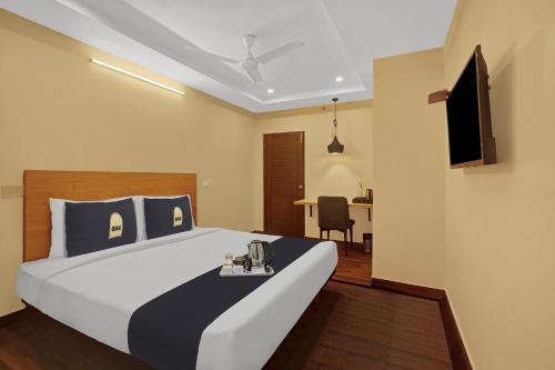 a hotel room with a bed and a table at Capital O De Alphabet Kakinada in Kākināda