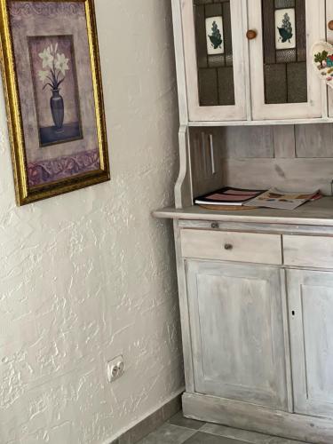 Pokój z białą szafką i zdjęciem na ścianie w obiekcie Domek Masuria w Orzyszu