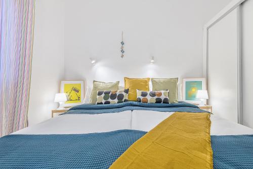 サン・バルトロメにあるBungalow Arcos 97のベッドルーム1室(大型ベッド1台、青と黄色のシーツ付)