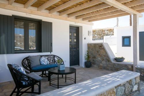 a patio with a table and chairs and a bench at Alko Apartments in Mýkonos City