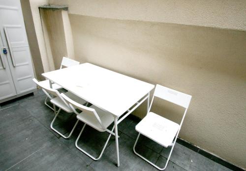 a white table and chairs next to a wall at Kusama All New Business Grade Comfort Apartment in Belgrade