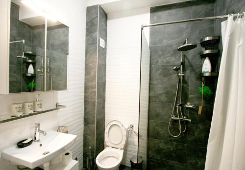 a bathroom with a toilet and a sink and a shower at Kusama All New Business Grade Comfort Apartment in Belgrade