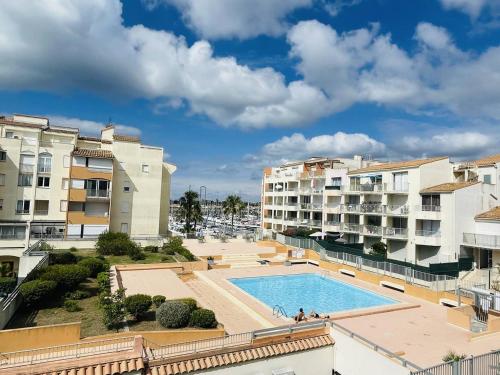 - une vue sur la piscine d'une ville avec des bâtiments dans l'établissement Appartement Près Plage, Port et Piscine, Parking Privé - FR-1-723-111, au Cap d'Agde
